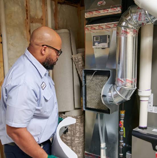 Technician inspecting a residential furnace and air filter
