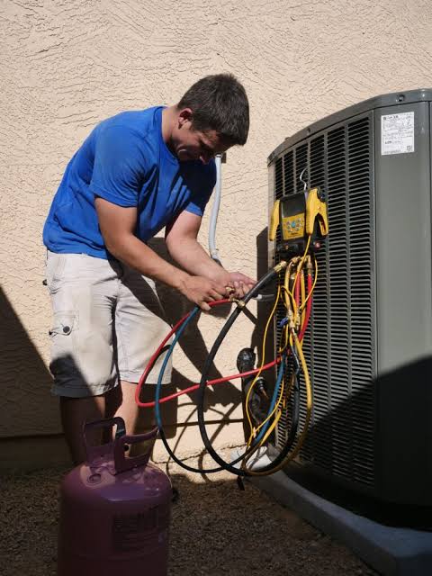 HVAC technician repairing residential air conditioning system