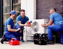 HVAC team examining a compact outdoor air conditioning system