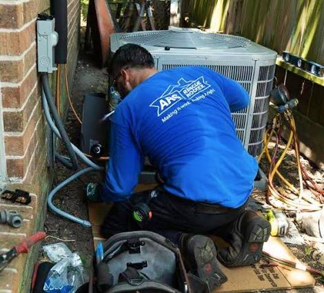 Technician servicing an outdoor residential air conditioning condenser